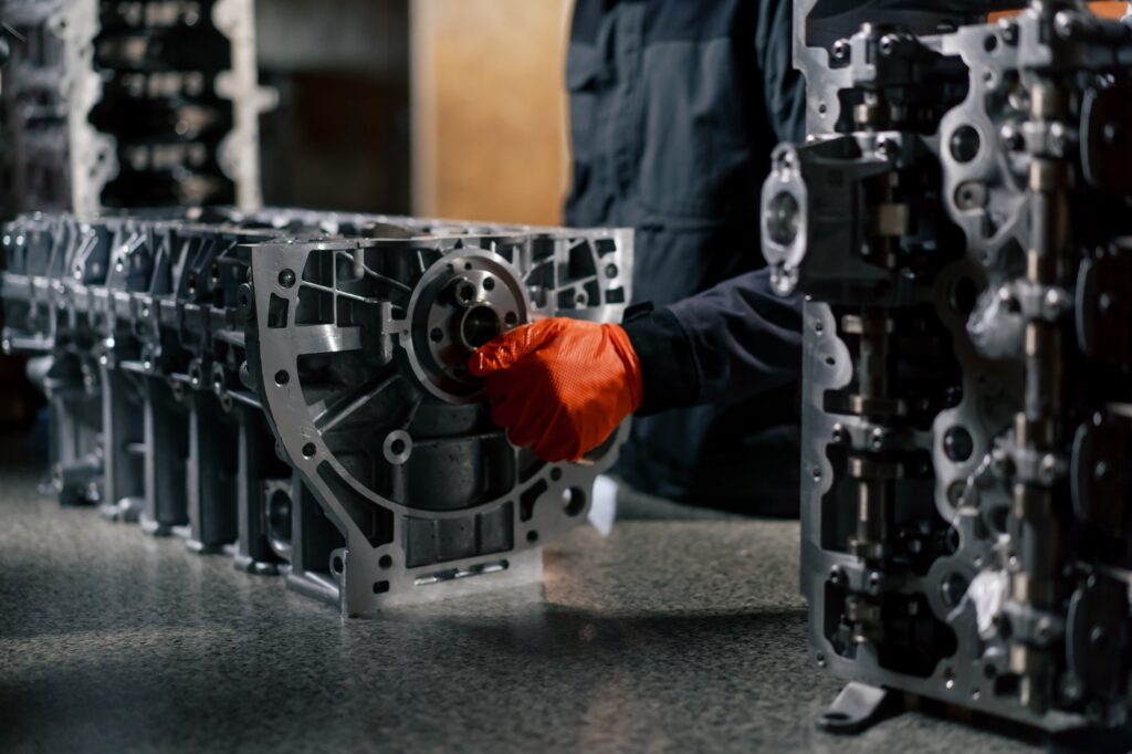service station on the table young engine repairman manually cranks the crankshaft in the engine